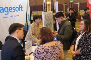 SAGESOFT and OutSystems team engaging with government attendees at the National ICT Summit 2026 Caption: The SAGESOFT and OutSystems team in conversation with government technology leaders at the summit exhibit floor.